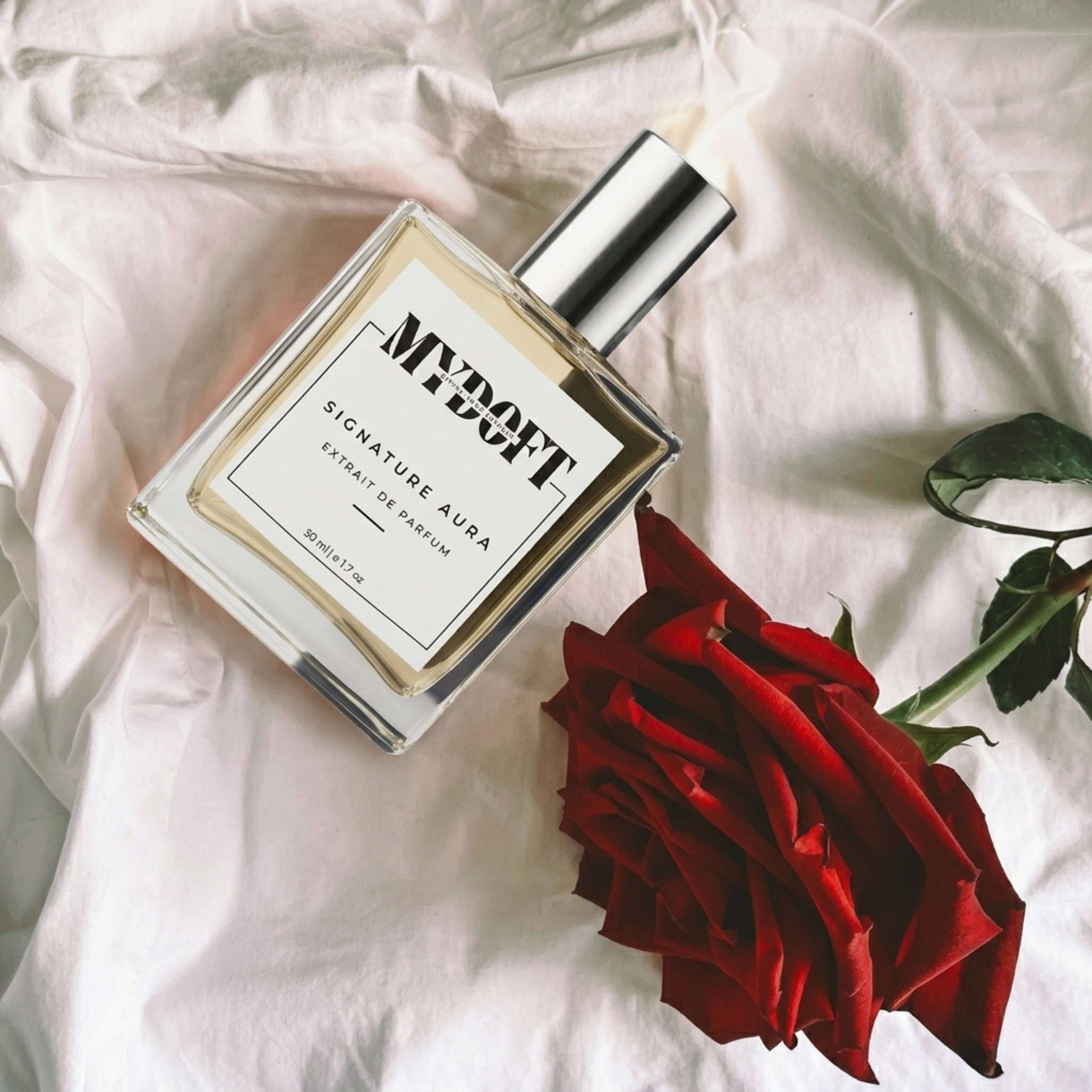MYDOFT SIGNATURE AURA PERFUME ON A BED WITH A RED ROSE